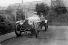 184. Type 13, Chassis # 1399, Reg. XM 4884 c1923. Owner Peter du Cane in tweed cap at the wheel of his car with Dick Rowland in trilby sitting alongside.